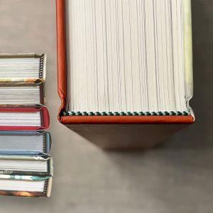 Head and tail bands are the little pieces of colored twine found on the top and bottom of the spine of hard case, hardcover books. Color choices for custom books.